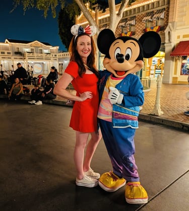 Woman taking picture with Mickey Mouse on Main Street USA at Disneyland. 