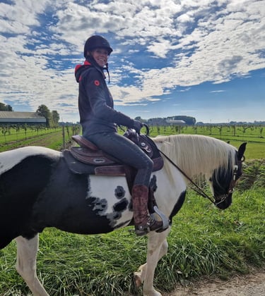 a woman riding a horse in a field