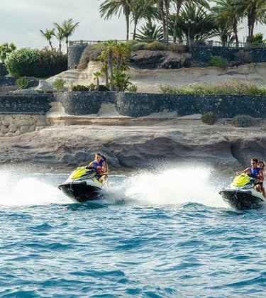 three people are riding on jet skis in the water