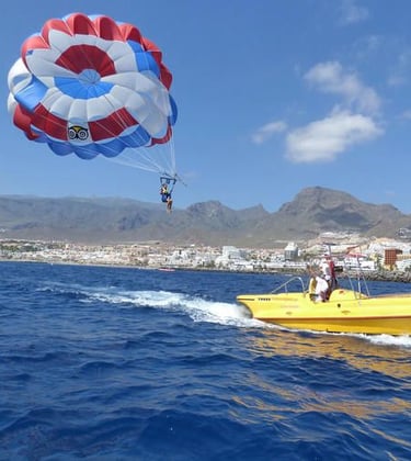 a person parasailing in the water with a parachute