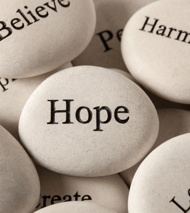 Inspirational rocks with positive words representing motivational books and survival guides