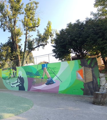 Green wall mural depicting sports like tennis, hiking, and orienteering in a public park setting.