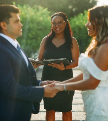 A wedding officiant performing a ceremony at Bonnet Springs, for a bride and groom holding hands.
