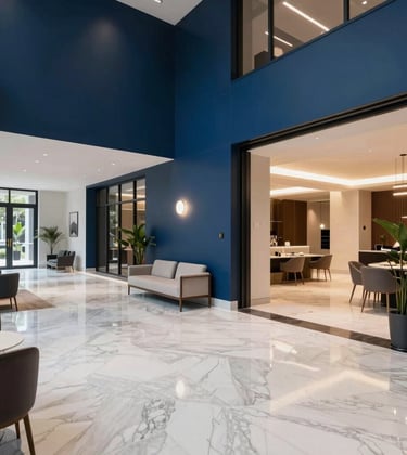 A photography shot of a luxurious interior lobby of a high-end South Asian apartment complex. The space features white marble flooring, deep blue accent walls, and modern minimalist furniture. Professional architectural lighting emphasizes the sophisticated and reliable brand image.