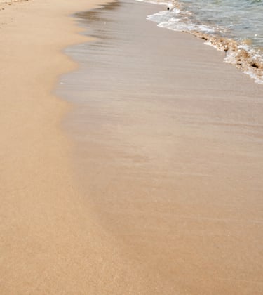 South American / Brazilian secluded pristine beach with golden sand, warm beige and light sand tones, gentle waves, luxury minimalist retreat setting, quiet and peaceful atmosphere.