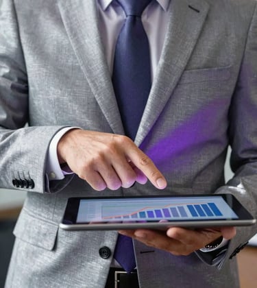 A close-up photograph of a professional banking consultant in a North American / US office, wearing a silver-grey suit, pointing to a sleek tablet displaying financial growth. High-end lighting with deep purple shadows and sharp, silver highlights.