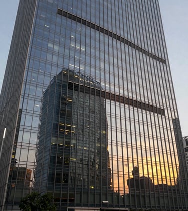 A focused shot of a modern glass skyscraper reflecting a sunset in a South Asian business district, symbolizing contemporary corporate law and high-stakes tax planning.