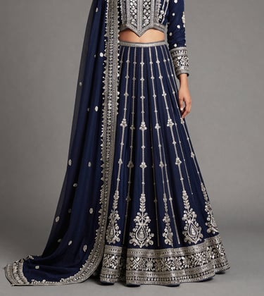 A studio product photograph of a designer South Asian / Indian ethnic garment. The piece features intricate silver zari work on a deep navy fabric, draped elegantly to showcase the premium quality and craftsmanship of Surat's clothing industry.
