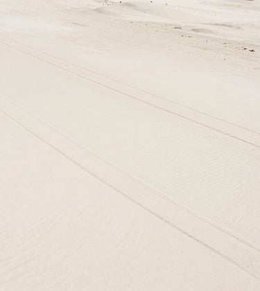 An aesthetic shot of a kite surf bar and lines laid out on white sand, minimalist and clean, capturing the preparation before the movement. Warm sunlit sand tones #DDCAB8 and #FAF8F5.