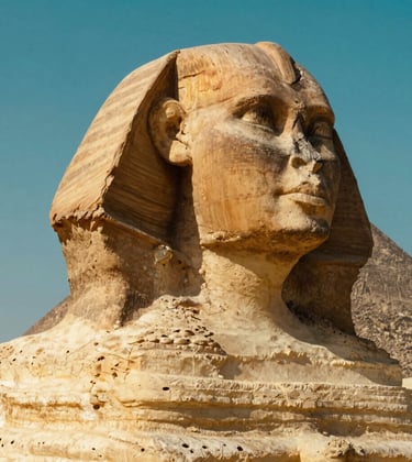 A breathtaking close-up of the Great Sphinx at Giza. The texture of the ancient stone is highlighted by the midday sun in Warm Sand tones. The sky behind it is a clear, vibrant Deep Egyptian Teal.