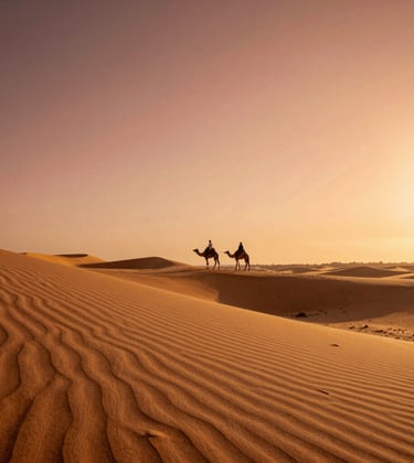 A wide, golden beach in Agadir during late afternoon, with soft desert sand dunes in the foreground and a silhouette of a camel rider against a warm terracotta sunset.