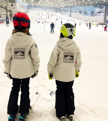 two young children are standing in the snow
