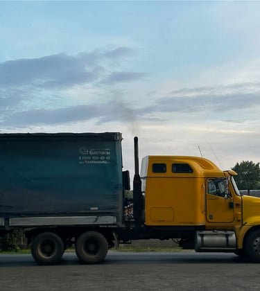 Un camión de carga con contenedor en la carretera, representando los servicios de transporte
