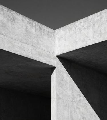 Minimalist black and white architectural detail showing the play of shadow and light on a modern concrete structure in Portugal.