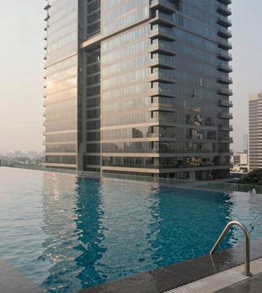 An upscale infinity pool located on the rooftop of a Greater Noida skyscraper. The lighting is soft and natural, emphasizing a sophisticated atmosphere. The style is professional architectural photography with slate gray and off-white tones.