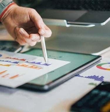 Tablet showing graph with person pointing, illustrating measurable business results.