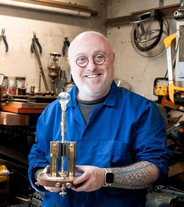 Mains de Yann Franconie, artisan fabricant de luminaires présentant une lampe dans son atelier