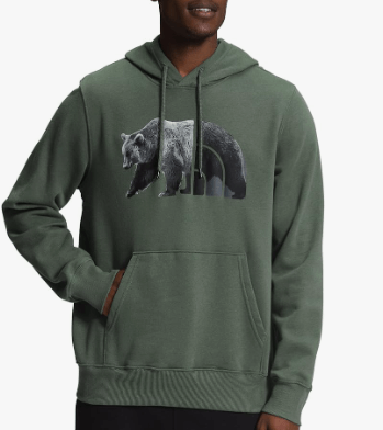 a man in a green hoodie with a bear in the background