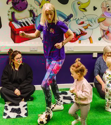 Action shot of Farmer Becca in the Moo Room dancing with a child.