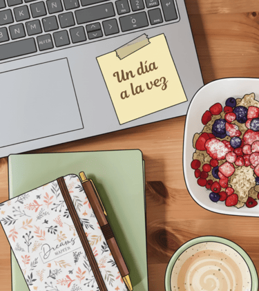 Detalle de taza de café junto a materiales de trabajo en un entorno organizado