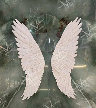 two white angel wings on a marble table