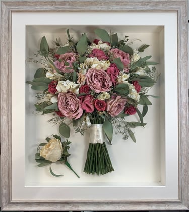 a soft pink side view preserved wedding bouquet with buttonhole in a frame