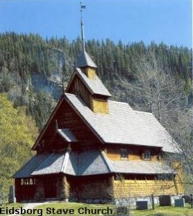 A wooden stave church with pine trees in the background