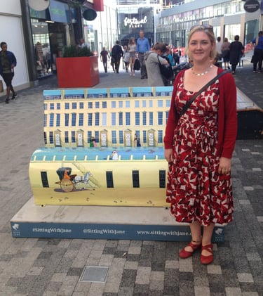 Laura Fearn with her street sculpture book bench featuring Bath Street scenes.