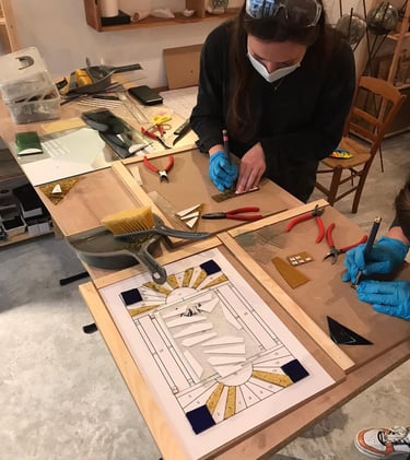 Stage de vitrail à Paris : élèves en apprentissage découpe du verre.