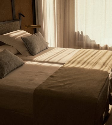 Hotelzimmer mit warmem Sonnenlicht und Doppelbett – Interior Fotografie