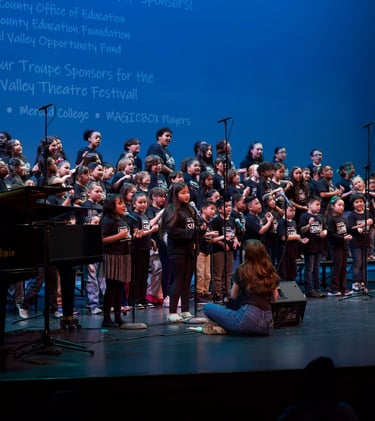 A youth choir performing on stage at the Central Valley Theatre Festival with a Baldwin piano.
