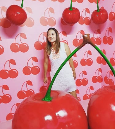 a Japanese woman standing in front of a wall with cherries