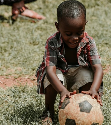 a young boy is playing with a soccer ball