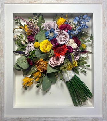 a Side view Style bouquet of flowers  in a thin white frame