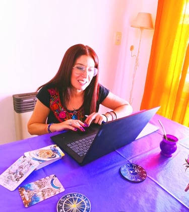 a woman sitting at a table with a laptop and a laptop
