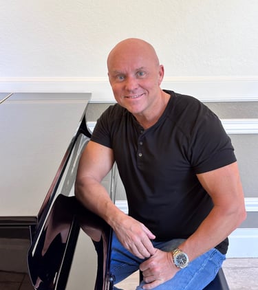 Composer Mark Bulmer Sitting at Piano