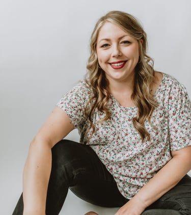 a woman sitting on a white surface with a white background