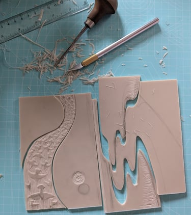 a jigsaw linocut print being assembled with printmaking tools on desk