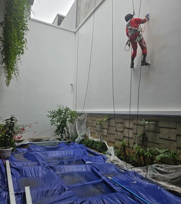 a man climbing up a wall on a rope