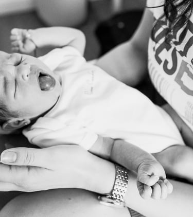 a mother is holding a baby in her arms while the baby yawns