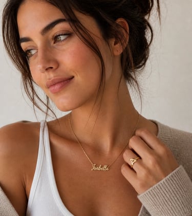 A woman wearing a personalized gold name necklace and a gold triangle ring.