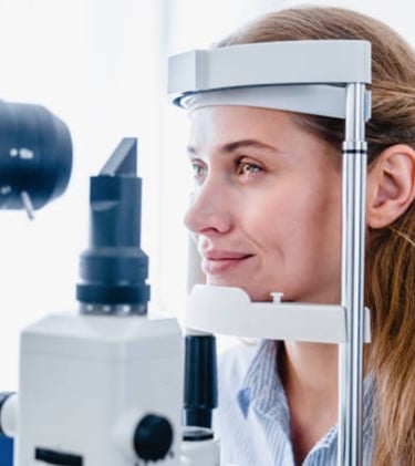 a woman is looking through a microscope at a doctor
