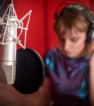 woman wearing headphones next to microphone