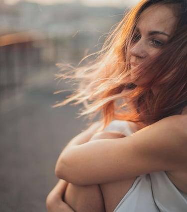 a woman with red hair and a white dress
