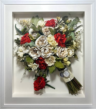 a side view preserved wedding bouquet with bright red and white roses and a memorial pin