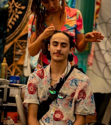 a women at a festival braiding a mans hair