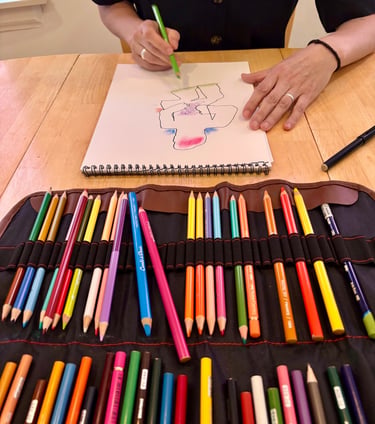 In an expressive arts therapy session, a client is drawing a figure using coloured pencils