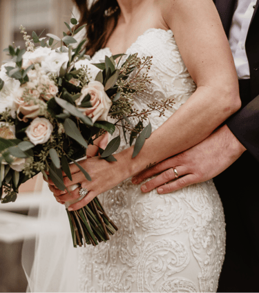 a bride and groom holding a bouquet of flowers