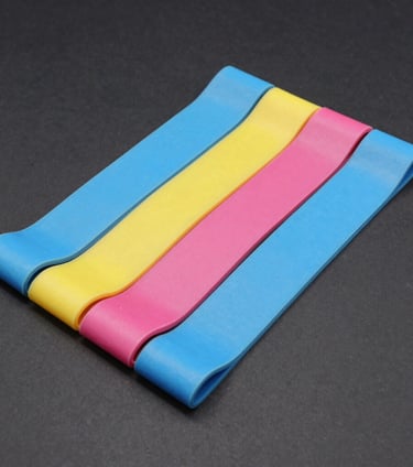 A neatly arranged set of colorful resistance bands on a light wooden floor.