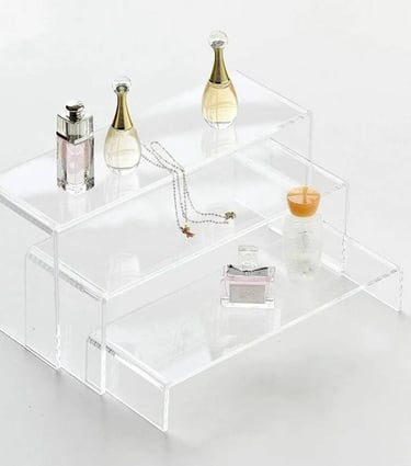 Acrylic risers displaying elegant perfumes and delicate jewelry, enhancing item visibility and decor